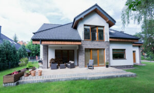 Modern two-story residential home with brick accents and a spacious patio, representing homeownership and credit investment.