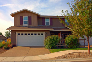 Brown two-story suburban house with an attached garage and paved driveway